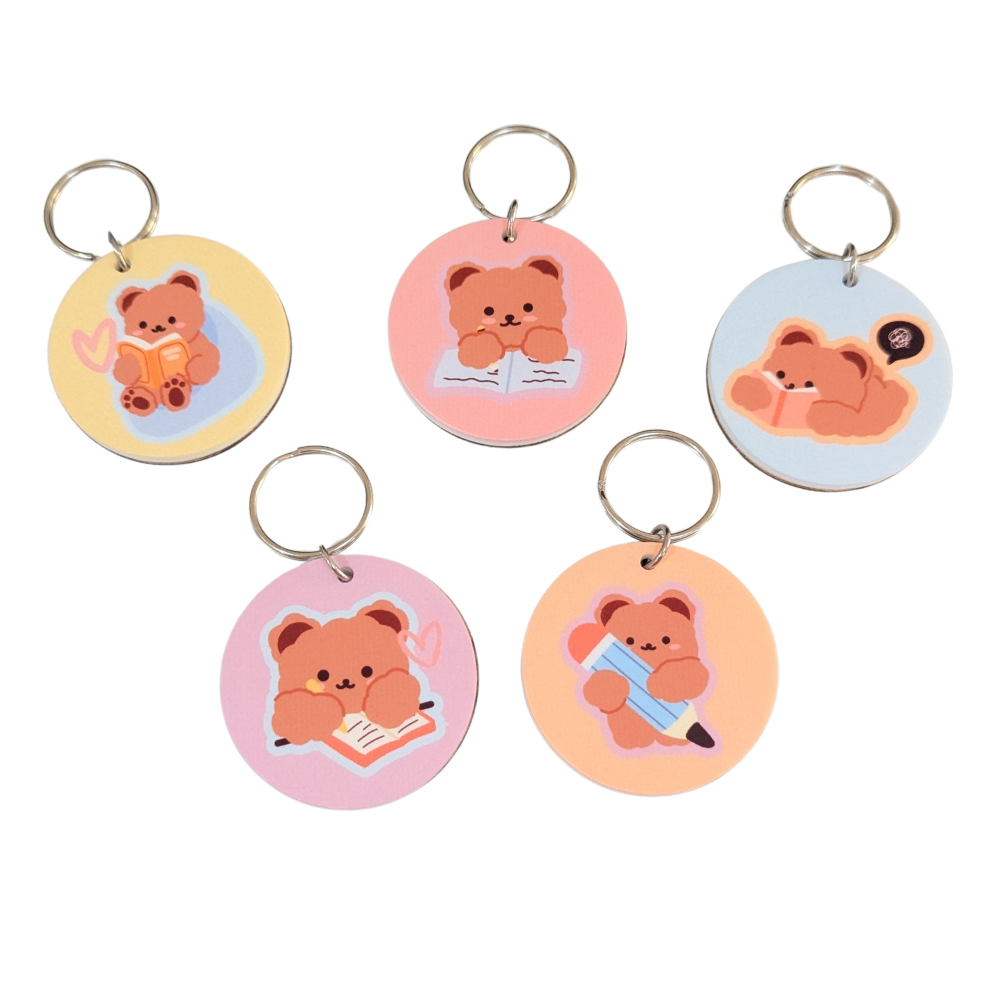 Adorable pastel bear keyring collection featuring study and pencil bear designs with eco-friendly engraved bamboo backing