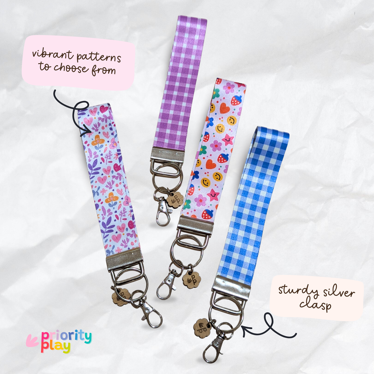 Handmade wristlet keychains with purple floral, heart, and blue gingham patterns, durable silver clasp key fobs for teachers.