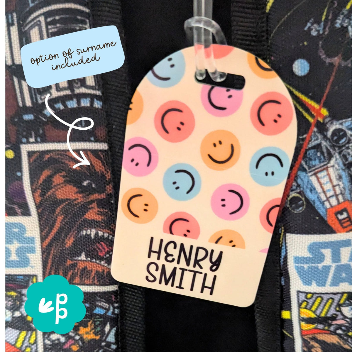 Personalised bag tag with custom name and surname option featuring colourful smiley pattern, durable kids luggage tag by Priority Play