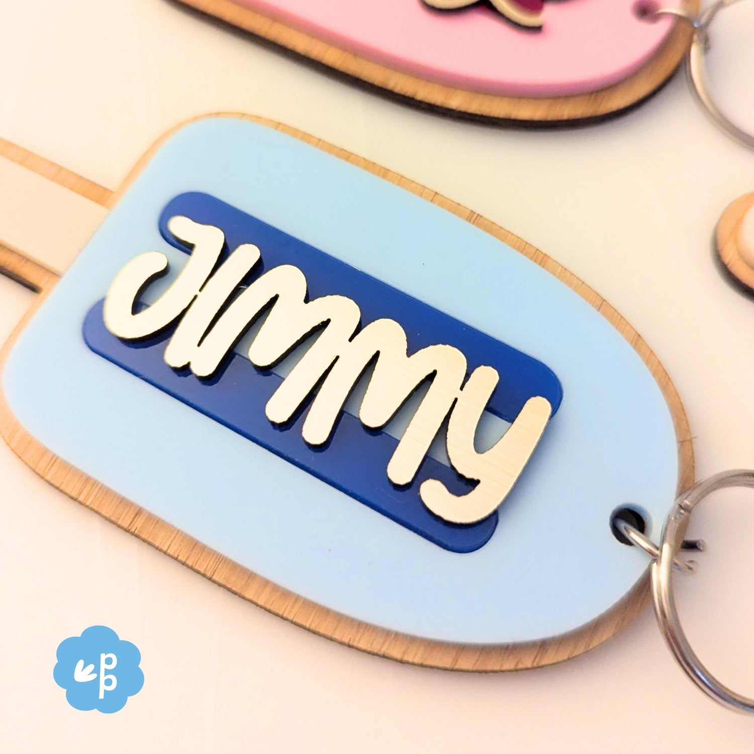 Close up of personalised name keychain with layered acrylic and bamboo backing in popsicle shape, featuring custom script name