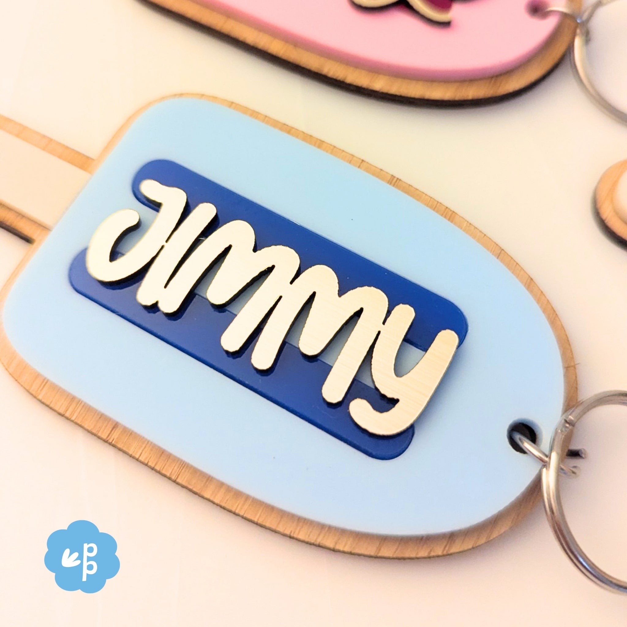 Close up of personalised name keychain with layered acrylic and bamboo backing in popsicle shape, featuring custom script name