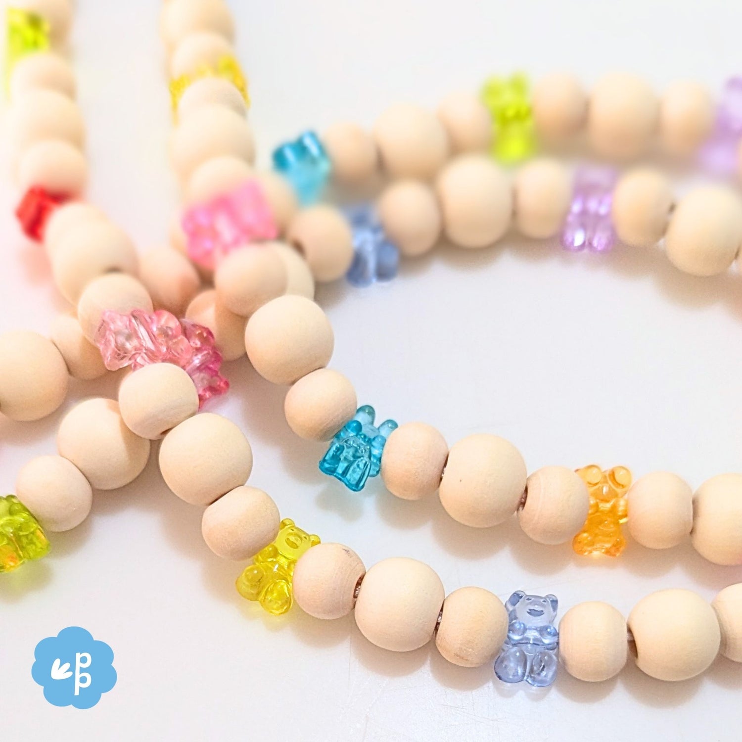 Close up of handmade beaded lanyard with wood beads and bright gummy bear beads in rainbow colours