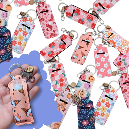 Collection of colorful lip gloss holder keychains with ice cream, cherry, strawberry and floral prints — fun and practical accessory by Priority Play.