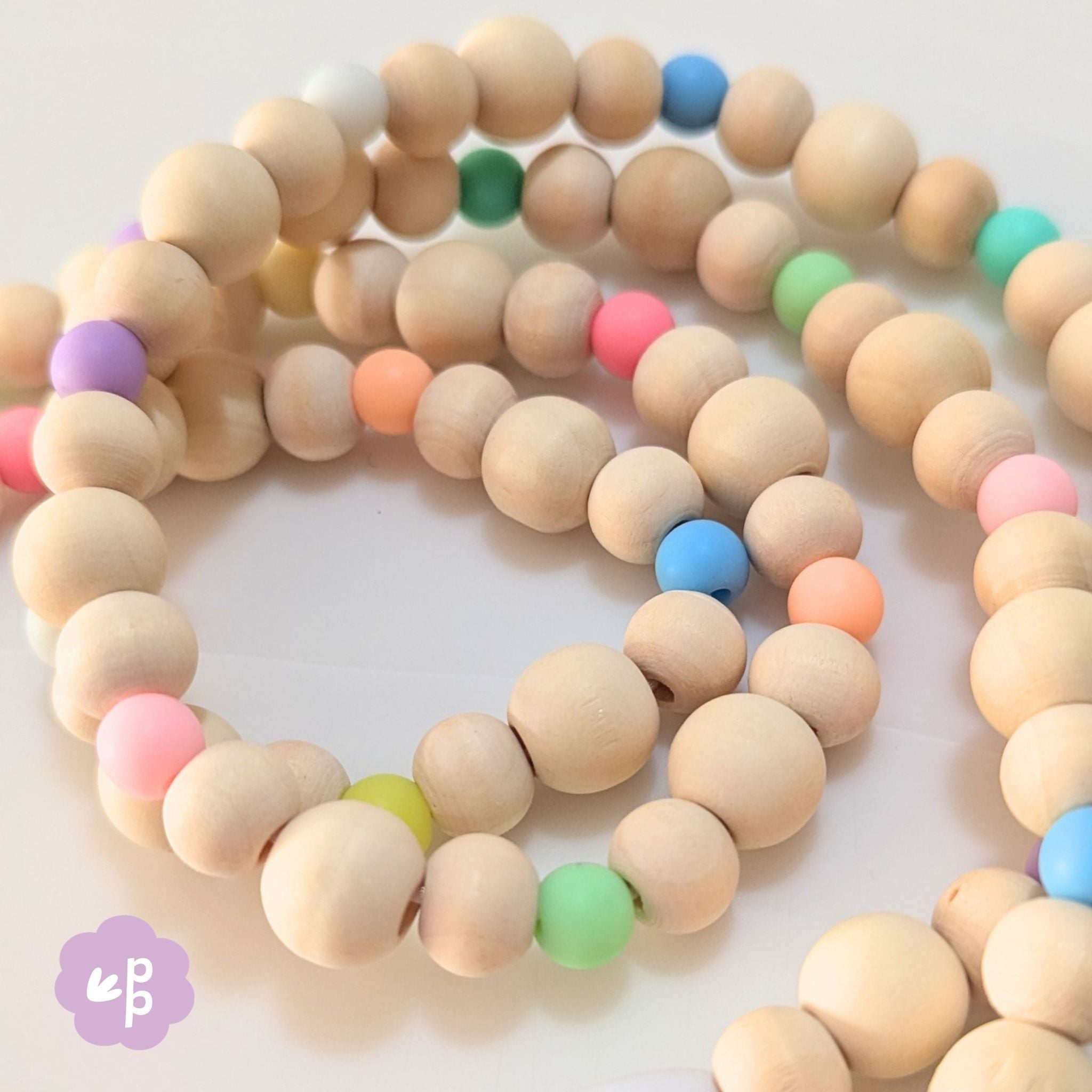 Close up of pastel beaded lanyard with wooden beads and soft colourful accents for teacher use