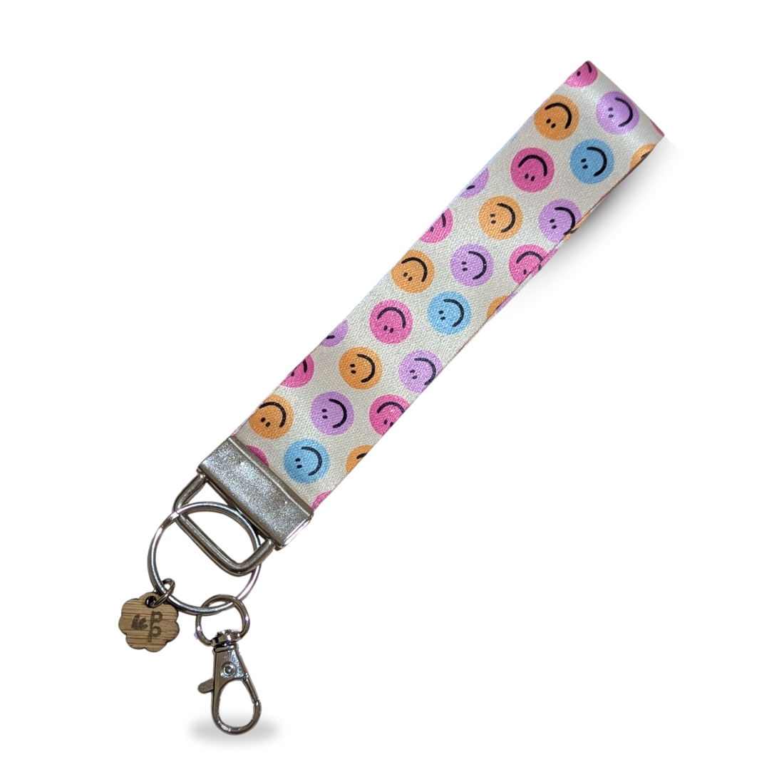 Handmade pastel smiley face fabric wristlet keychain, cheerful and ideal for everyday use or gifts.