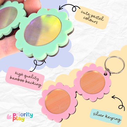 A collection of pastel flower-shaped sunglasses keyrings featuring bamboo backing and silver keyring hardware, perfect for teachers and students.