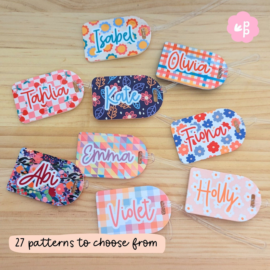 Colorful personalised bag tags with various patterns on a wooden surface