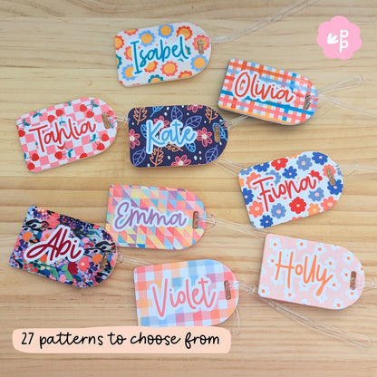 Colorful personalised bag tags with various patterns on a wooden surface