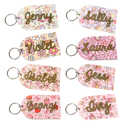 Personalised teacher keyrings with gold name cutouts on colourful floral and pastel patterns, ideal teacher or student gift by Priority Play