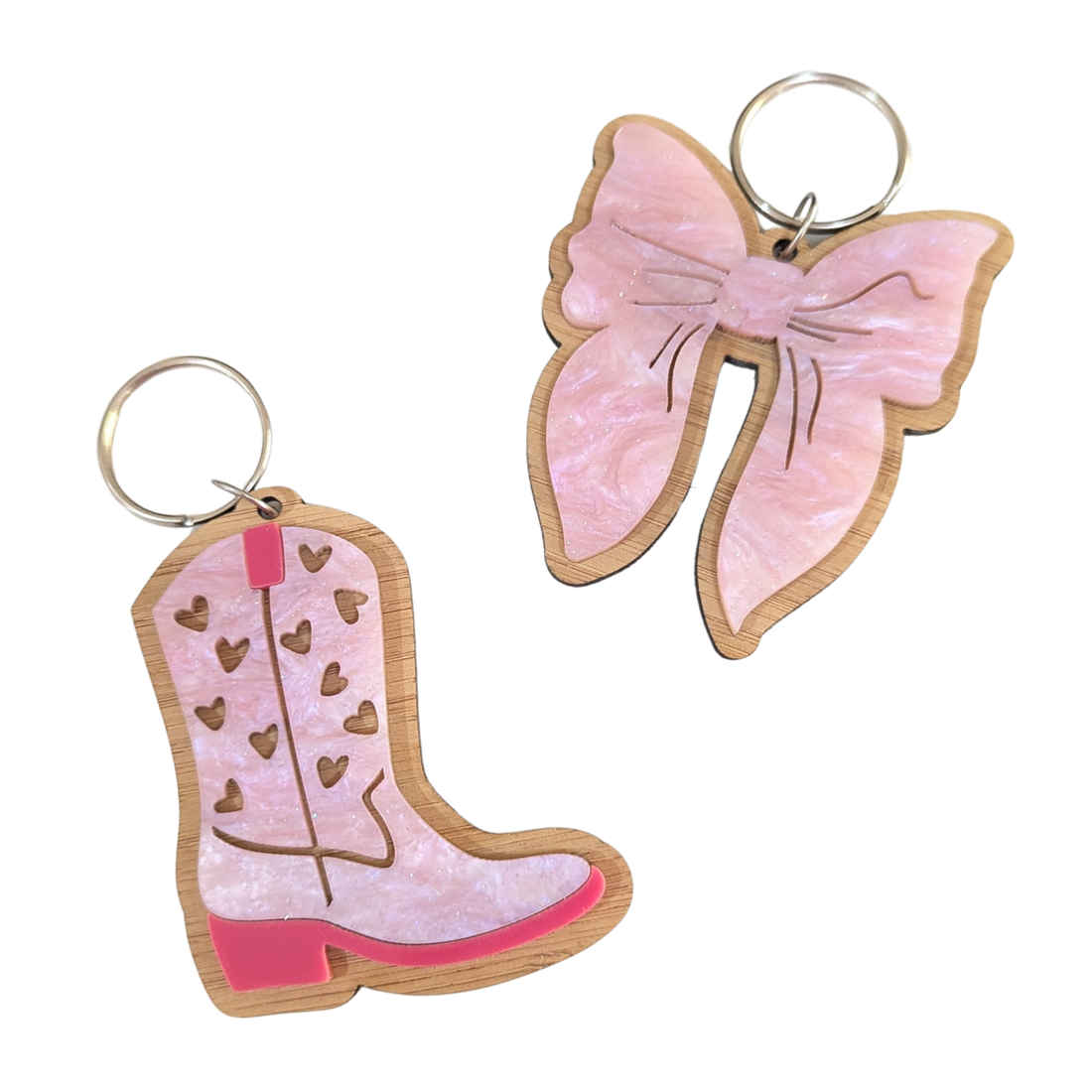 Pink cowboy boot and bow keyrings made from bamboo and acrylic with silver keyrings – fun and trendy accessories by Priority Play.