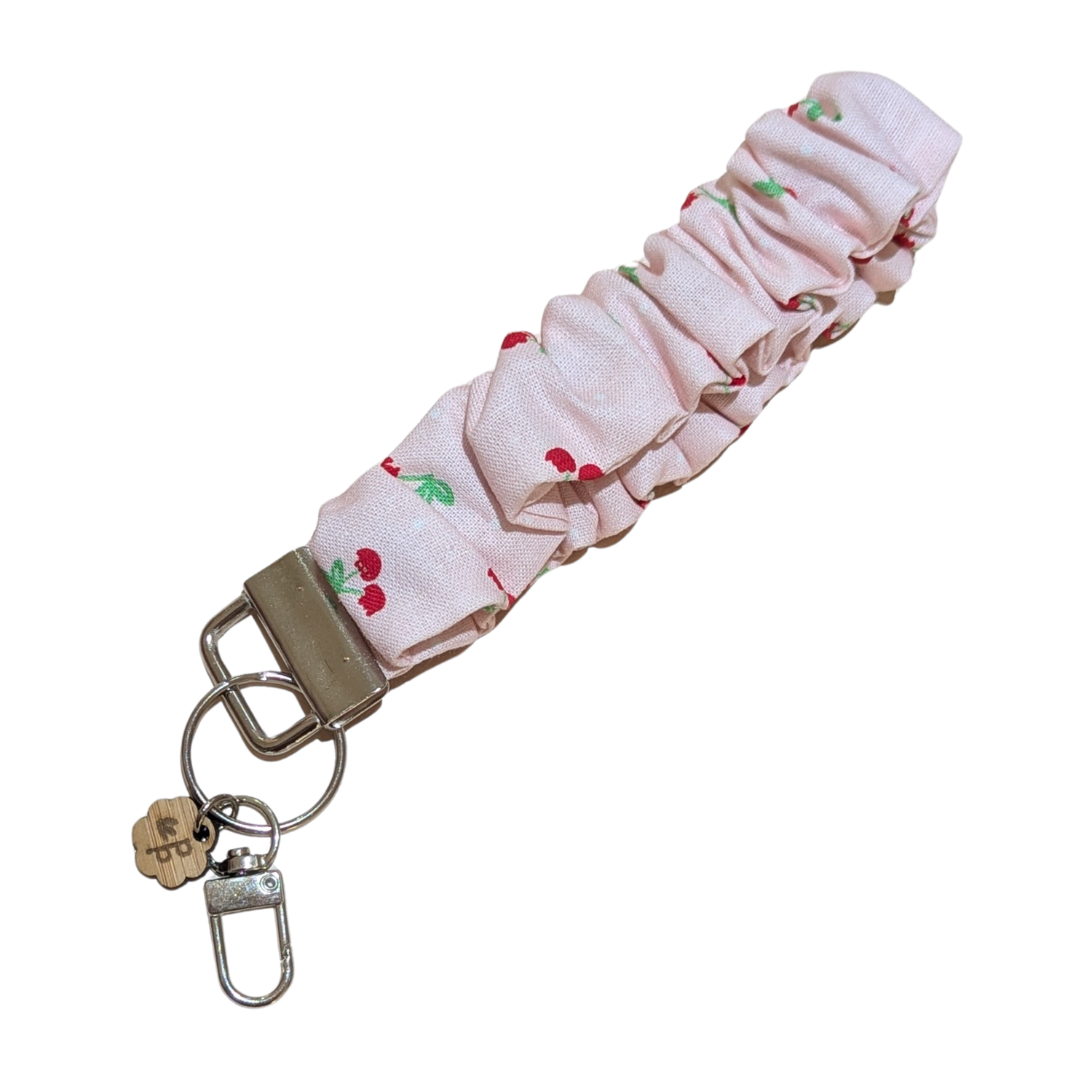 Handmade pink cherry scrunchie wristlet keychain by Priority Play, featuring soft gathered fabric and a sturdy silver clasp — perfect for holding keys or gifts for teachers.