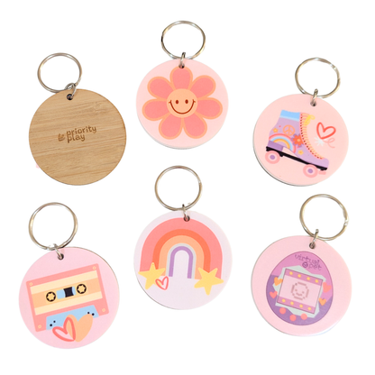 Full collection of 90s inspired bamboo keyrings including flower, cassette, rainbow, roller skate, and tamagotchi designs by Priority Play.