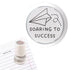 A teacher stamp showing a paper plane with a dotted trail and the message “Soaring to Success.”