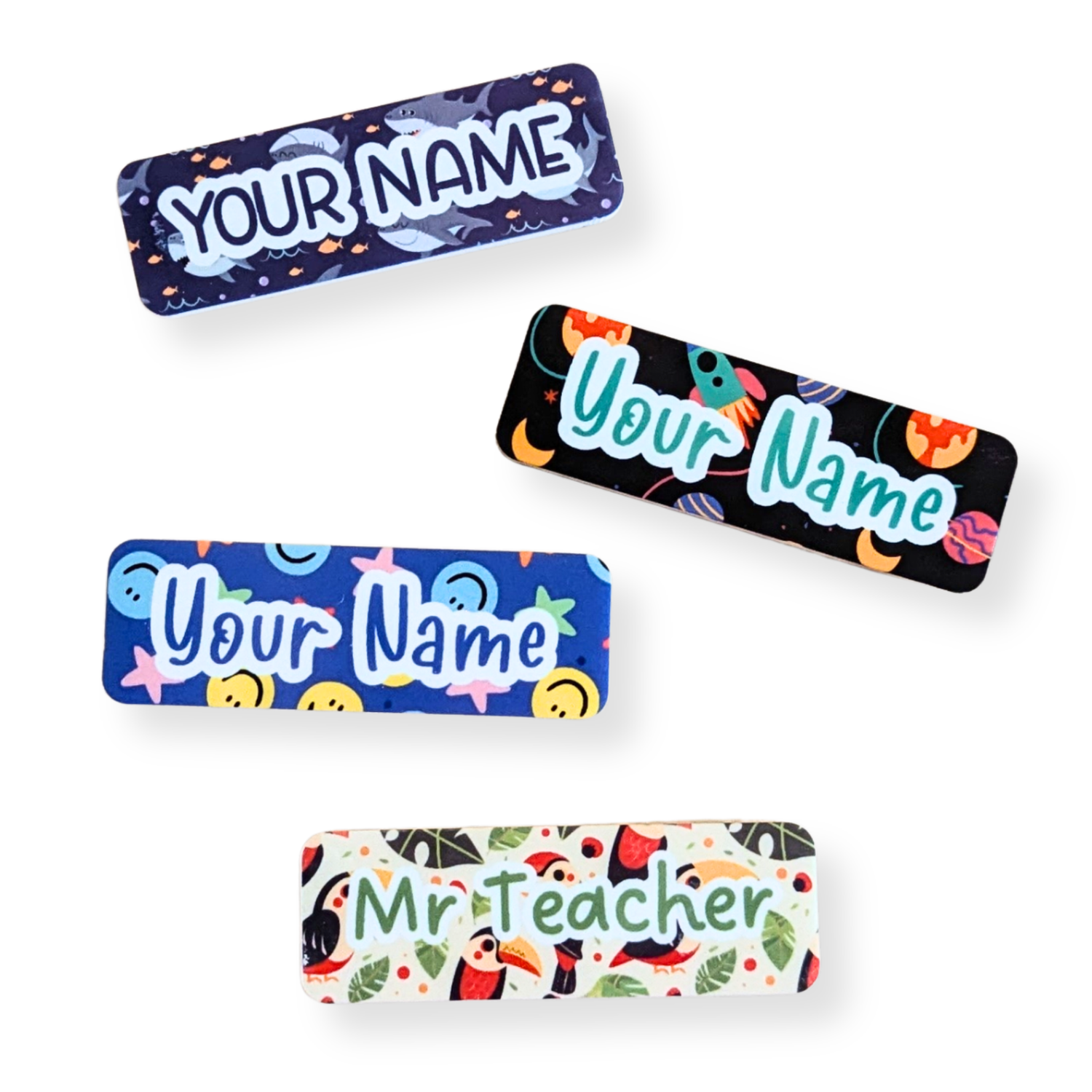 Unisex teacher name badges featuring fun patterns like sharks, rockets, smiley faces, and tropical birds on magnetic bamboo backings – customizable by Priority Play.