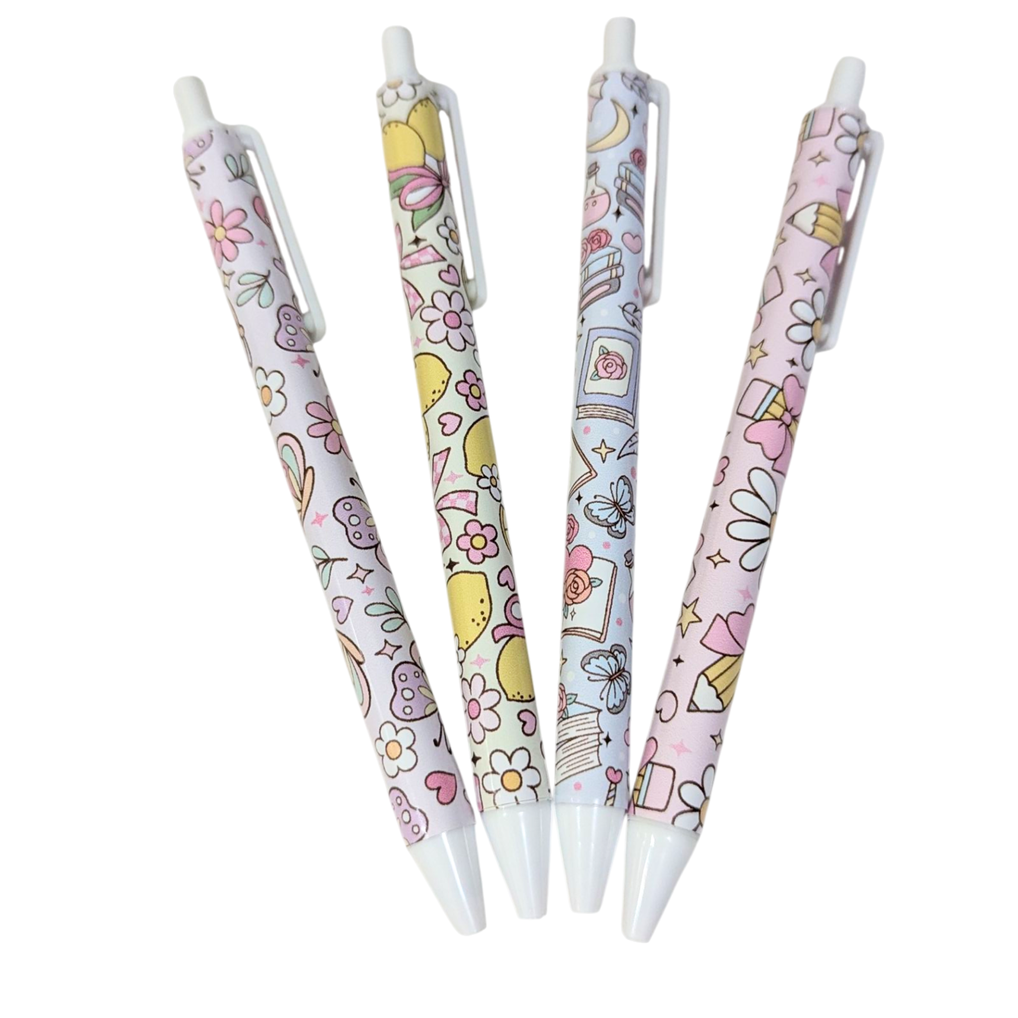 Four vinyl wrapped pens with pastel designs including lemons, daisies, and books, part of the handmade stationery collection by Priority Play.